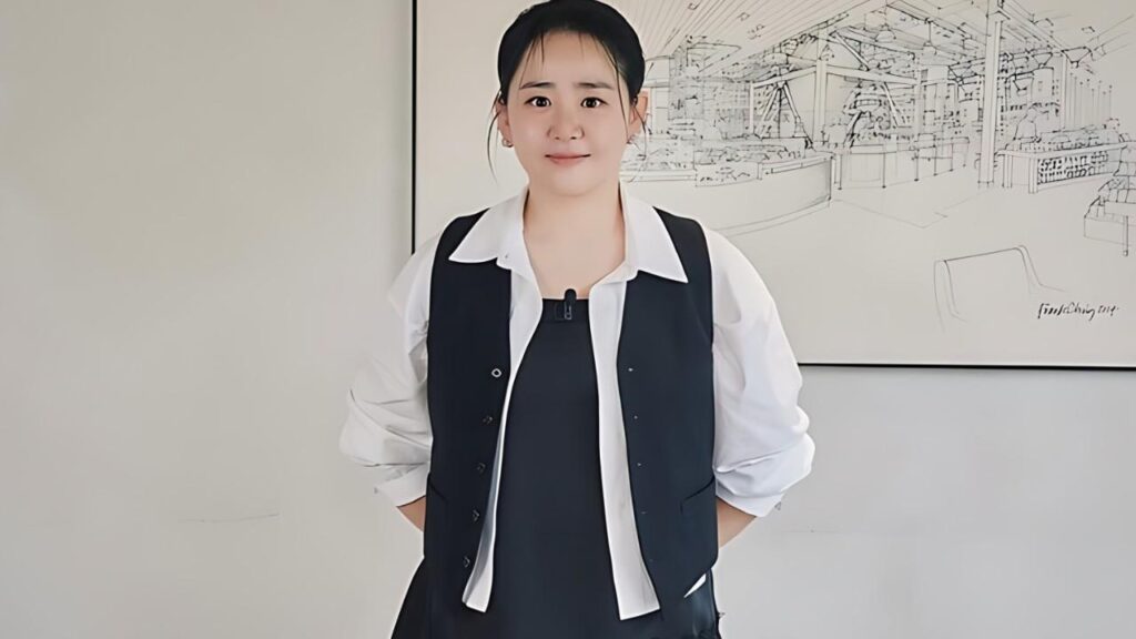 Moon Geun-young in a white blouse and dark vest stands in a bright room with hands behind her, a line drawing mural behind.