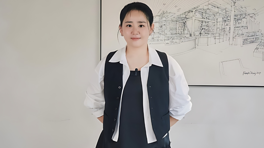 Moon Geun-young ( 문근영 ) in white shirt and dark vest faces camera, hands at her sides, mic clipped to collar, before line drawing mural.