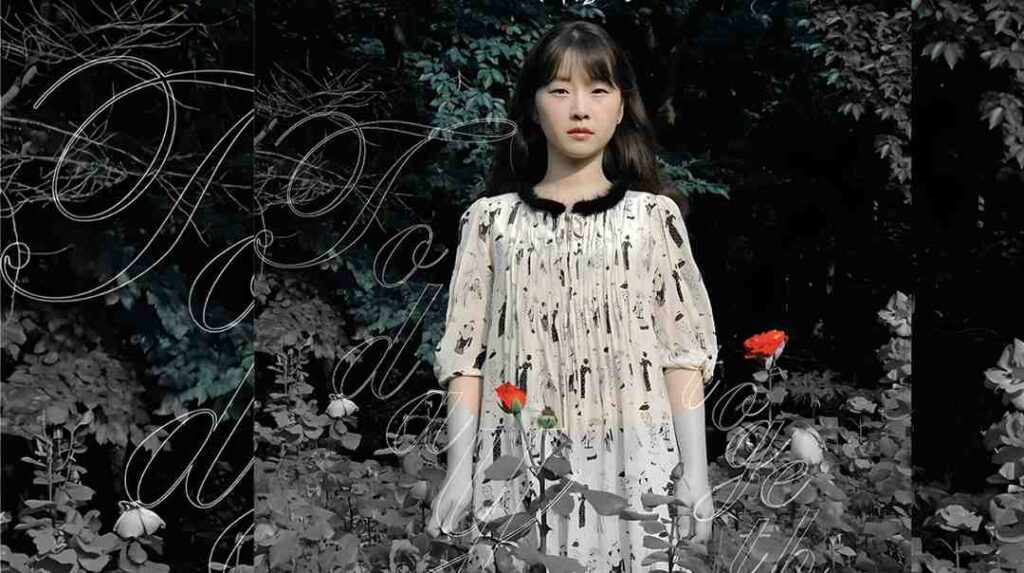 Jo Eun-ji in a cream dress with a black collar stands in a shadowy garden; red poppies, cursive text across the scene.